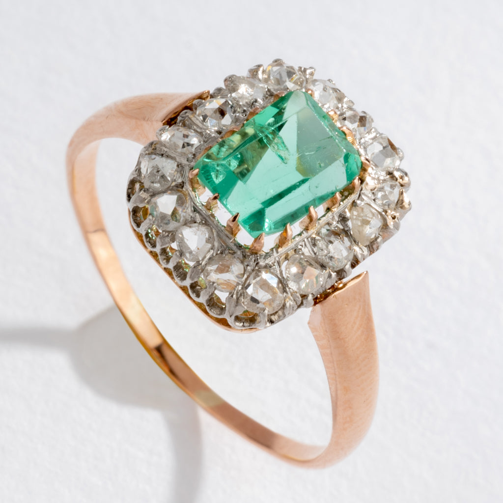Bague entourage émeraude et diamant.