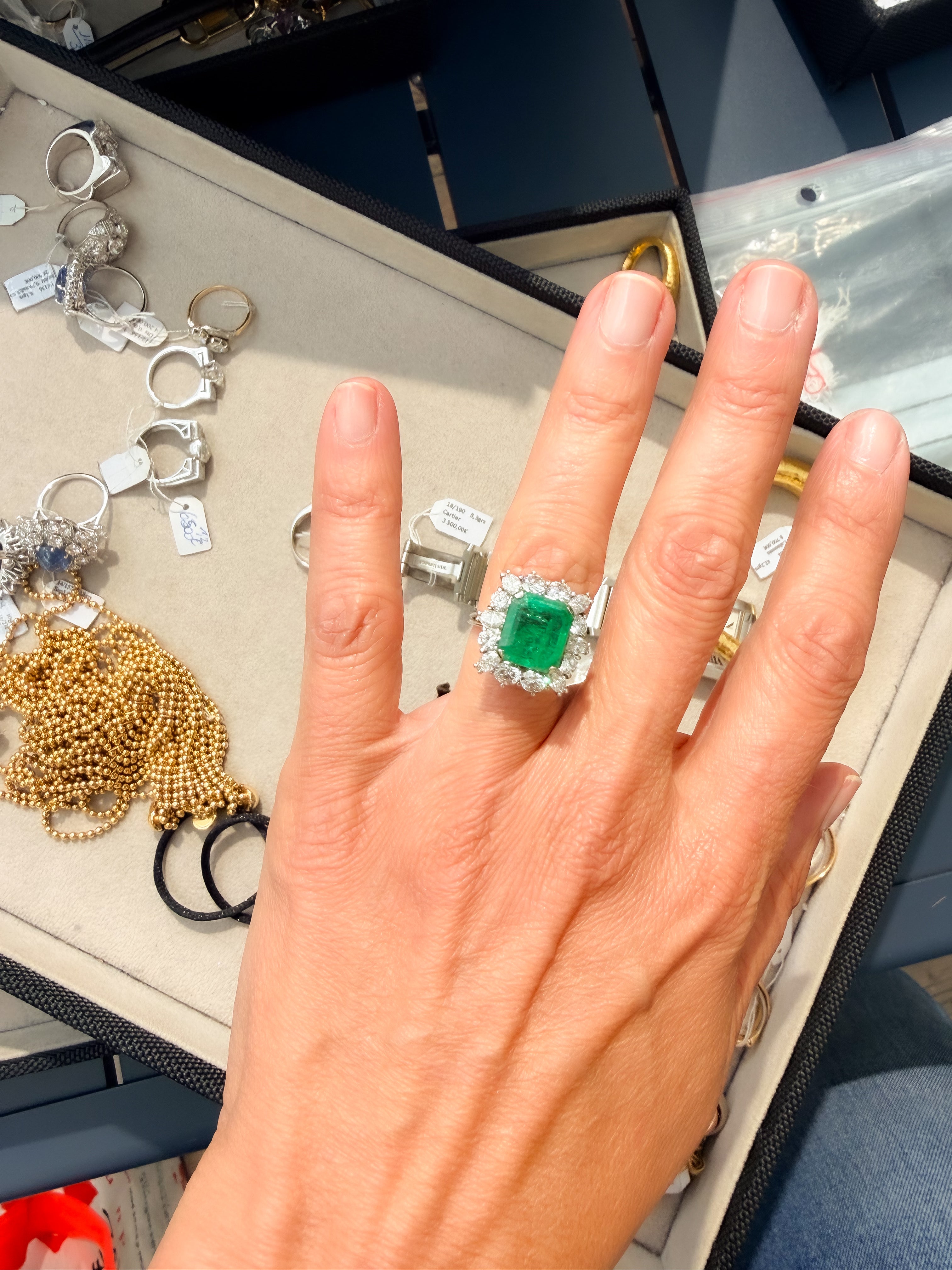 Bague en or gris avec Emeraude entourée de diamants