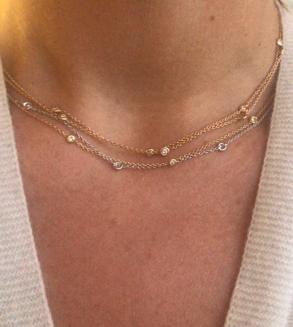 Collier or jaune intercalé de 9 diamants sur maille forçat en sertis clos.