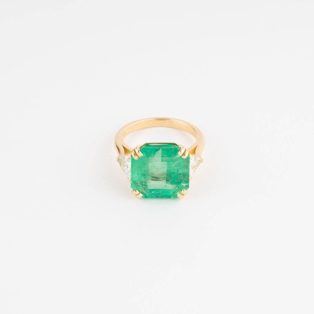 Bague en or jaune ornée d'une émeraude taille émeraude épaulé de diamants triangles